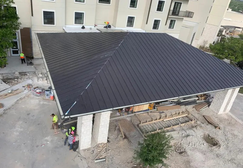 Metal roofing installation team working on a commercial building in Chelsea